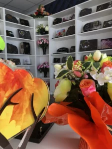 Articles et plaques funéraires présentés en boutique avec composition florale.