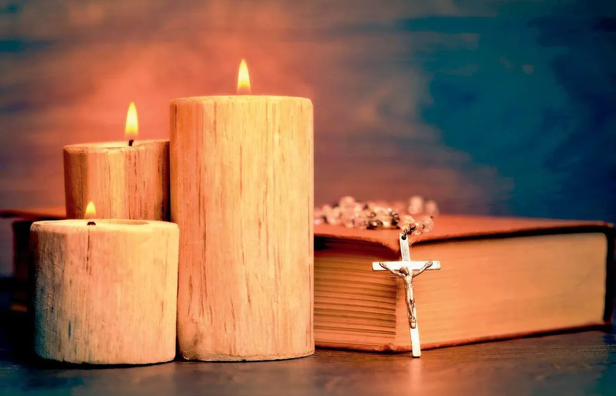 Bougies allumées, livre sacré et crucifix pour une veille spirituelle.